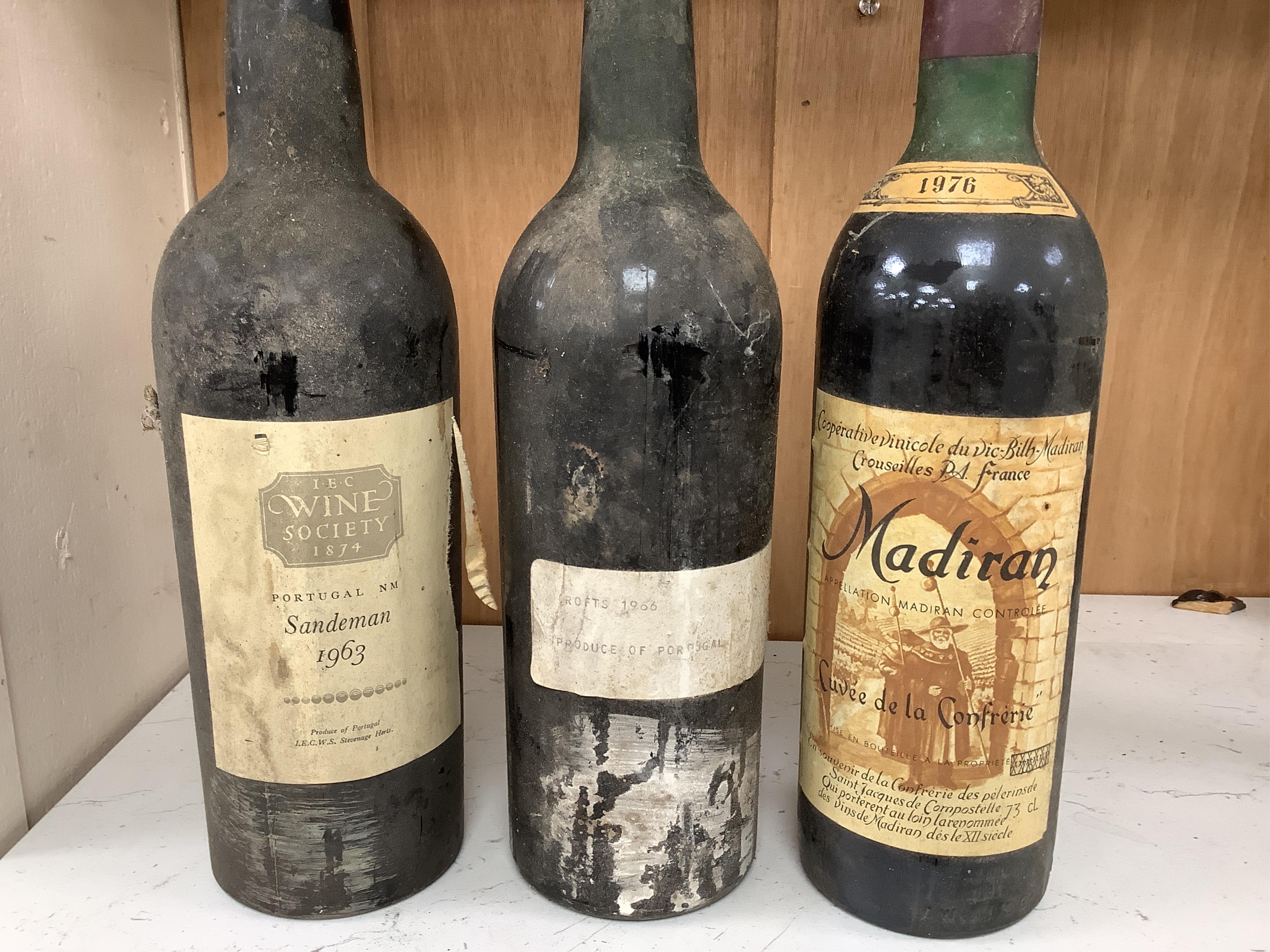 Fifteen bottles of wine and fortified wine, including; a Sandeman 1963 port, four bottles of Chateau La Rose Capbern 1953, a 1976 Madiran Cuvee de la Confrerie, etc. Condition - poor to fair, storage history unknown